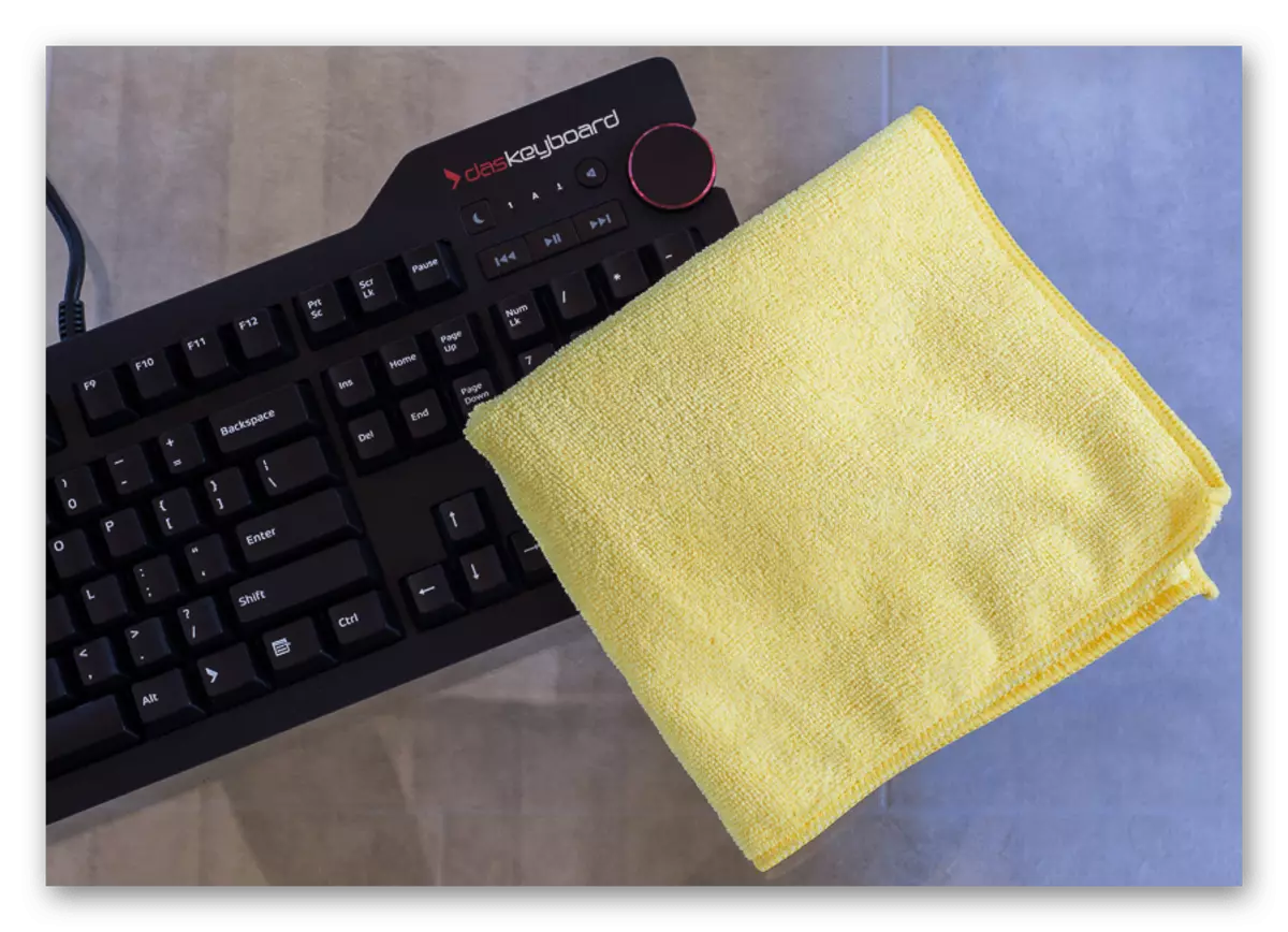 एक यांत्रिक कीबोर्ड की सतह की सफाई के लिए एक कपड़ा का उपयोग करना