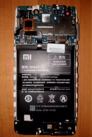 Xiaomi Redmi 4 con un coperchio posteriore rimosso e un tappetino di protezione. commissioni