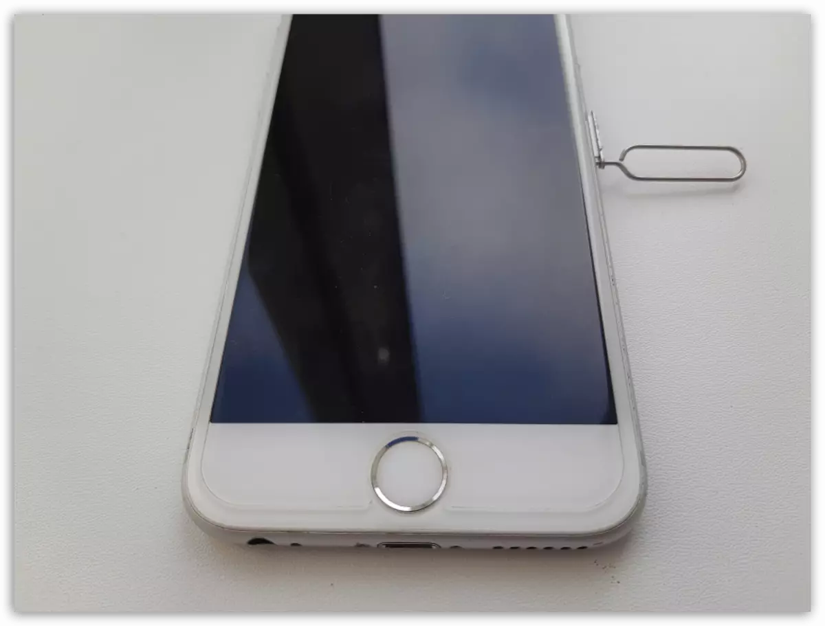ഒരു ക്ലിപ്പ് ഉപയോഗിച്ച് iPhone സിം കാർഡിനായി ഒരു സ്ലോട്ട് തുറക്കുന്നു