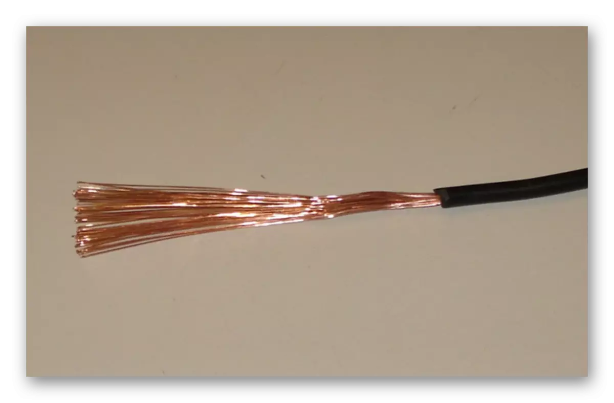 El proceso de preparación de un cable de cobre delgado para cargar una computadora portátil.